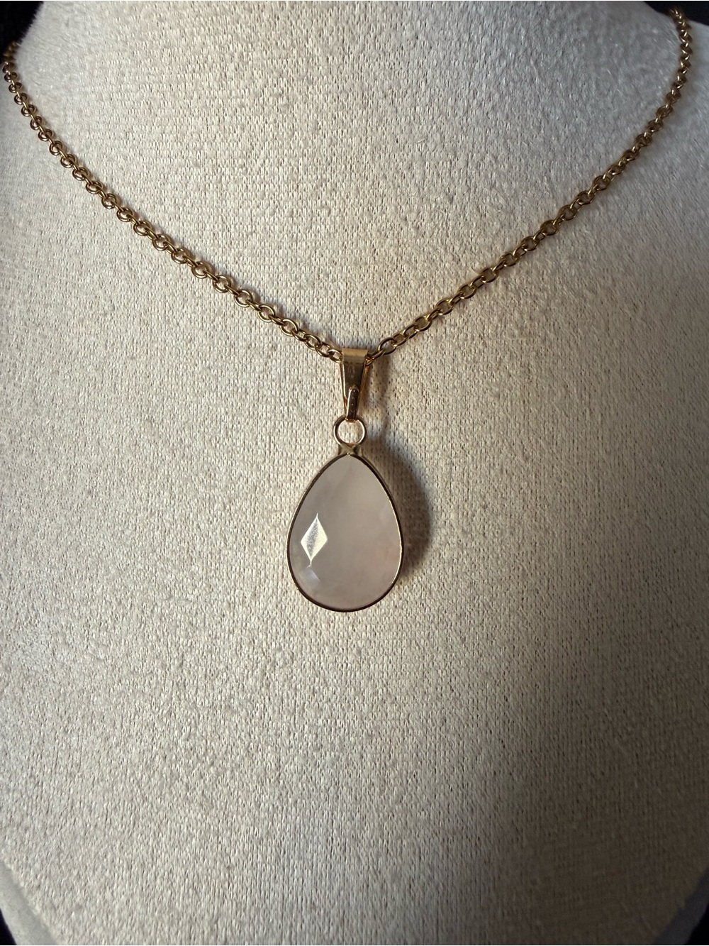 Stainless steel necklace with a teardrop- shaped rose quartz pendant and a gold